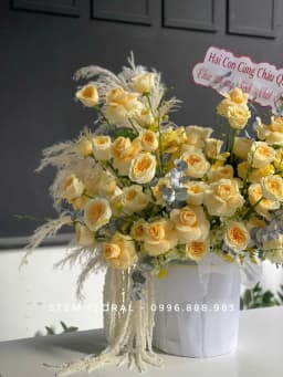 Góc 2 của Bình vàng kem thanh nhã — Các bông hoa vàng kem được cắm xòe ngang trong bình trắng có gân