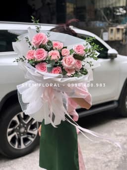 Góc 1 của Bó hồng vườn nhỏ — Hoa hồng phấn phối lá xanh đậm và các nhánh nhỏ màu sáng, được bó trong giấy trắng hồng