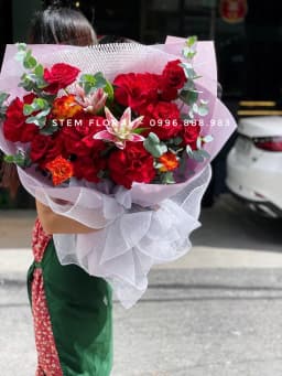 Góc 2 của Hồng đỏ giao duyên — Hoa hồng đỏ phối hoa ly cánh hồng viền sáng và lá xanh trong giấy trắng xếp mở