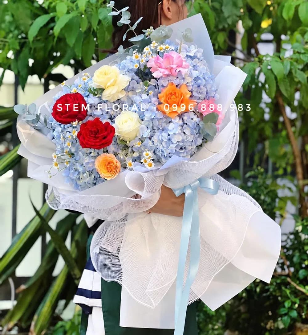 Lời chúc nhiều sắc hoa — Cẩm tú cầu xanh làm nền cho hoa hồng đỏ, kem và cam, xen những nhánh hoa nhỏ
