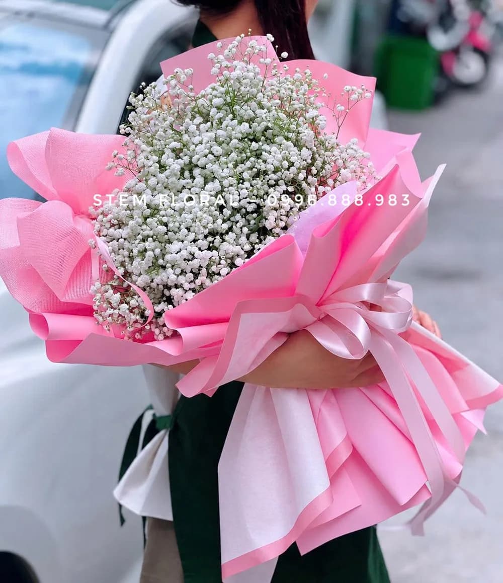 Mây trắng ngọt ngào — Những nhánh hoa nhỏ trắng được gom thành bó tròn trong giấy hồng đậm