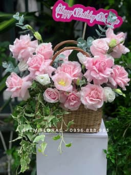 Góc 1 của Giỏ hồng dịu dàng — Những bông hoa hồng phấn với nhiều lớp cánh được cắm quanh quai giỏ mây