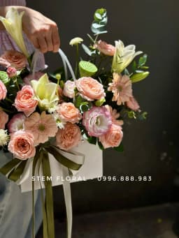 Góc 2 của Vườn hoa sắc đào — Các bông hoa sắc đào và hồng ấm được sắp xếp cao thấp quanh quai giỏ
