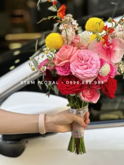 Góc 2 của Hồng rực cầm tay — Bó cầm tay để lộ phần cuống, phối hoa hồng sắc hồng đỏ cùng những điểm vàng tròn và hoa nhỏ
