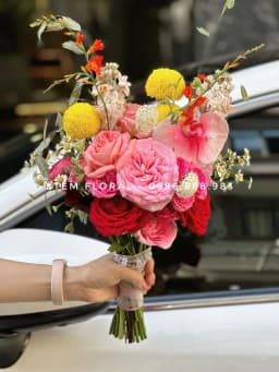 Góc 1 của Hồng rực cầm tay — Bó cầm tay để lộ phần cuống, phối hoa hồng sắc hồng đỏ cùng những điểm vàng tròn và hoa nhỏ