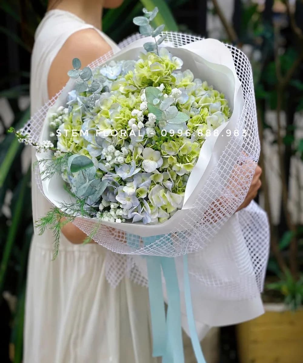 Xanh trắng tinh khôi — Bó hoa phối những cụm xanh nhạt, trắng và xanh non trong giấy gói sáng màu