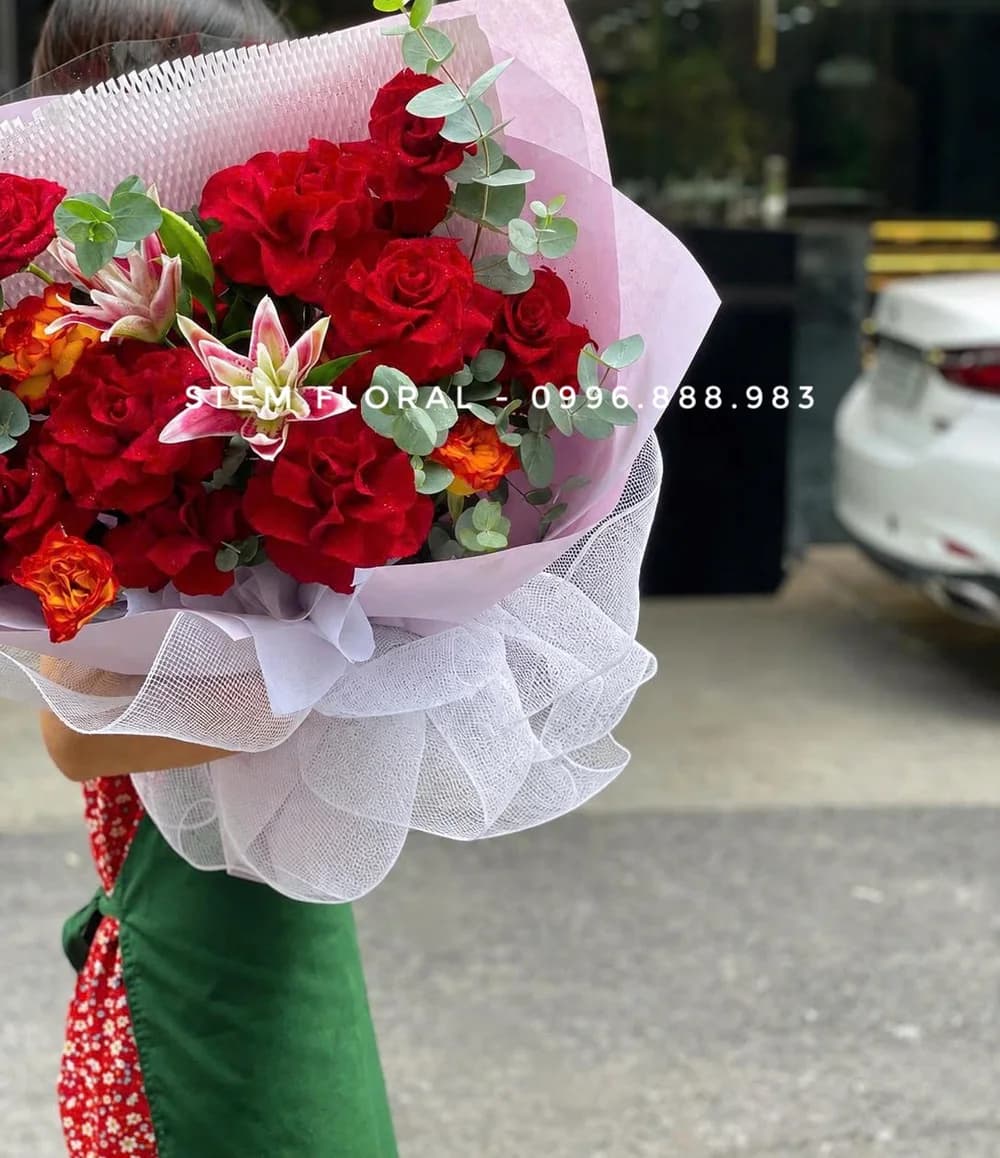 Hồng đỏ giao duyên — Hoa hồng đỏ phối hoa ly cánh hồng viền sáng và lá xanh trong giấy trắng xếp mở